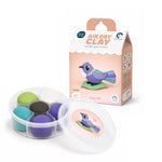 Load image into Gallery viewer, A children's air dry clay kit showing a clear round container with multiple coloured clay balls and a lid, alongside its retail box. The packaging features a purple bird illustration and the text 'Air Dry Clay, sculpt your own Tiny Tūī.'
